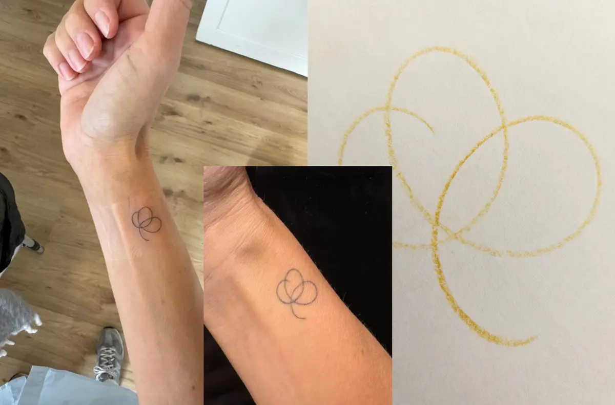 The finished single-stroke clover tattooed on the inside of my sister’s wrist, with the pencil drawing it was made from beside it